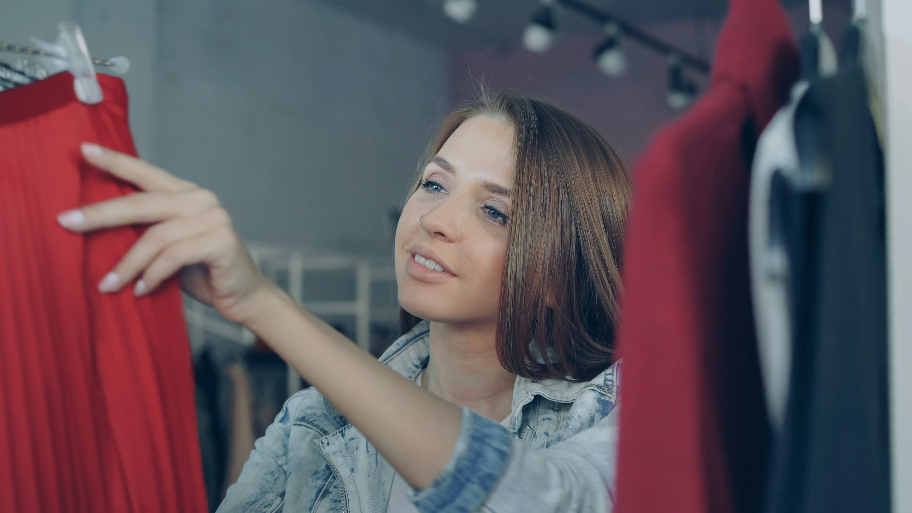 Woman browses clothing on a clothing rack.