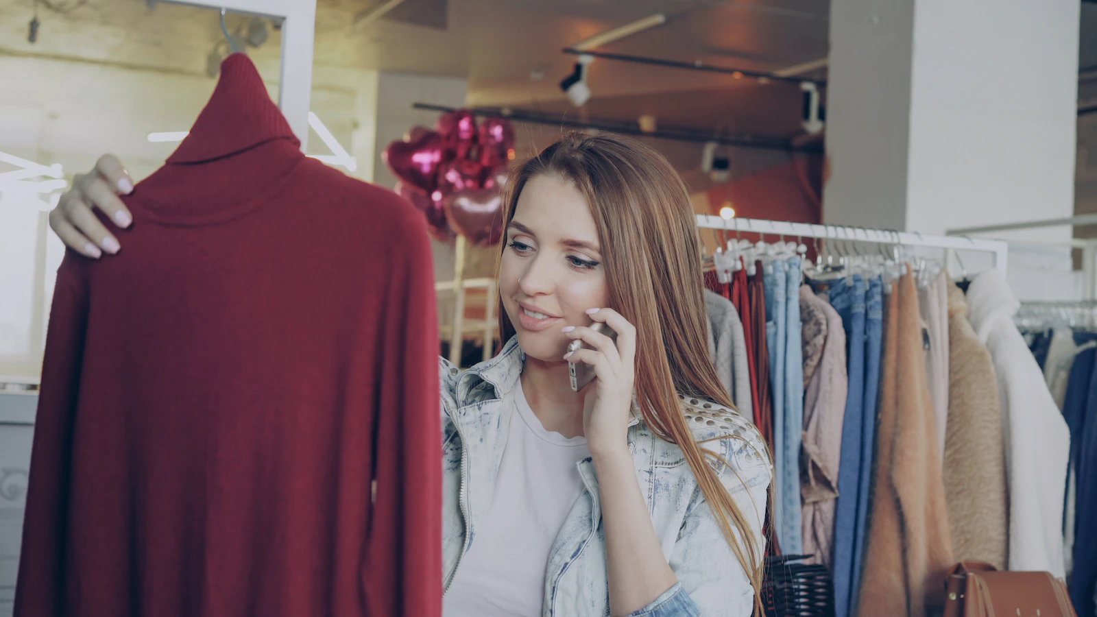A shopper checking her phone while browsing in a store, the moment an online cart usually starts