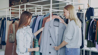 Two women shop together in a clothing store.
