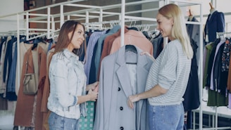 Two women shop for clothes at a clothing store.
