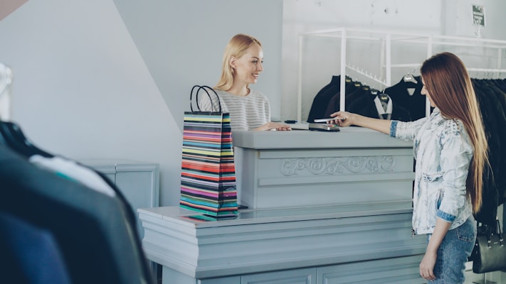 Consommatrice payant dans un commerce local equipe de solutions digitales