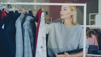 A woman chooses clothes from a rack.