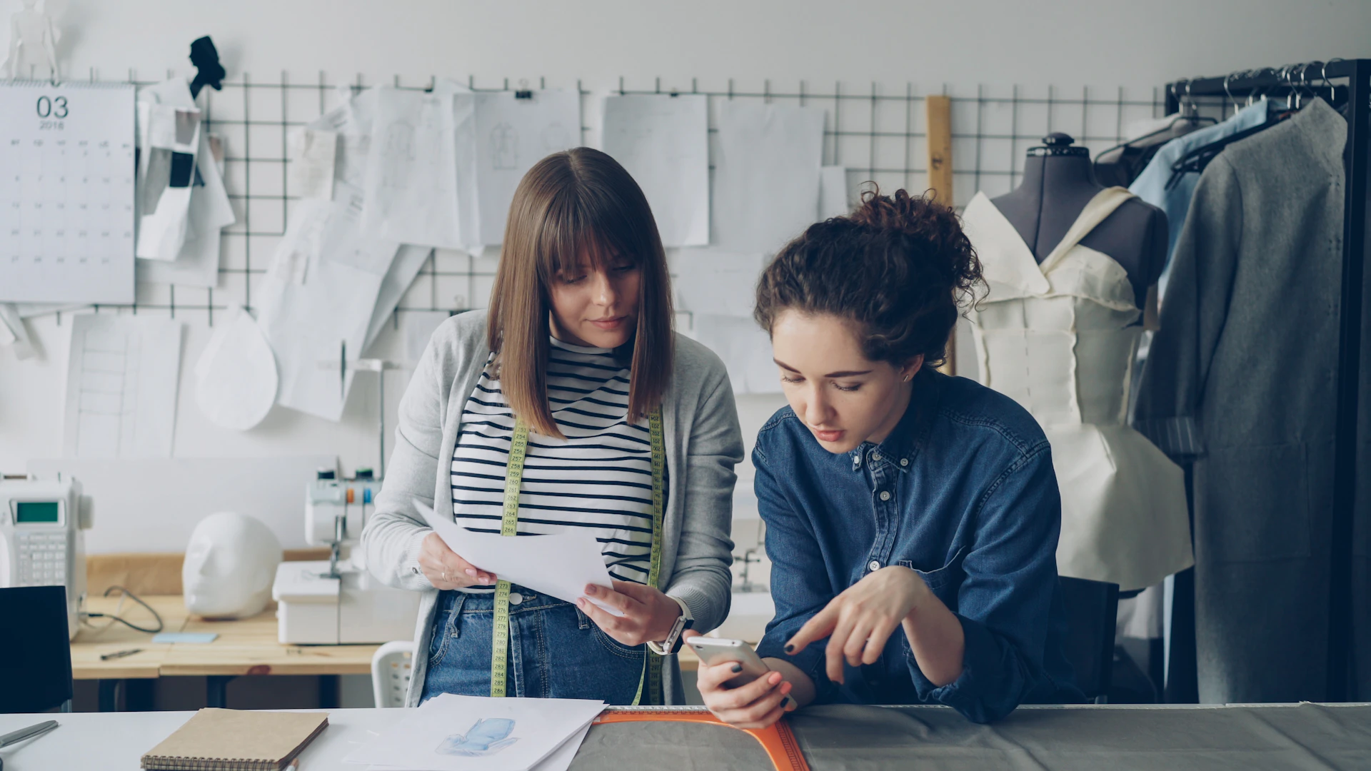 Two women collaborate on design work.