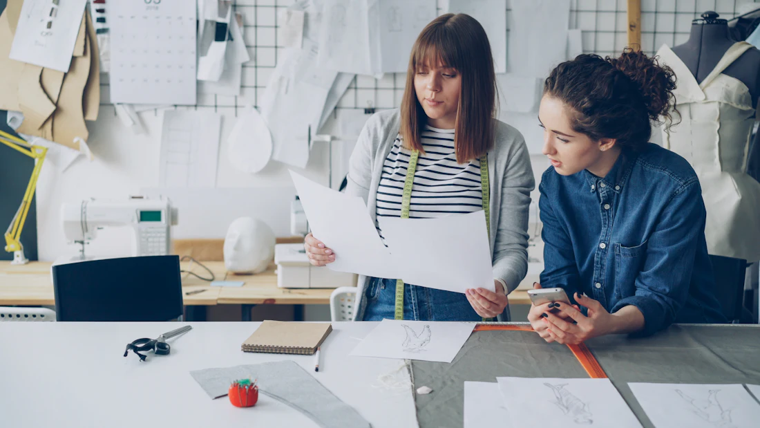 Twee collega's in een atelier bespreken samen hun ontwerpen