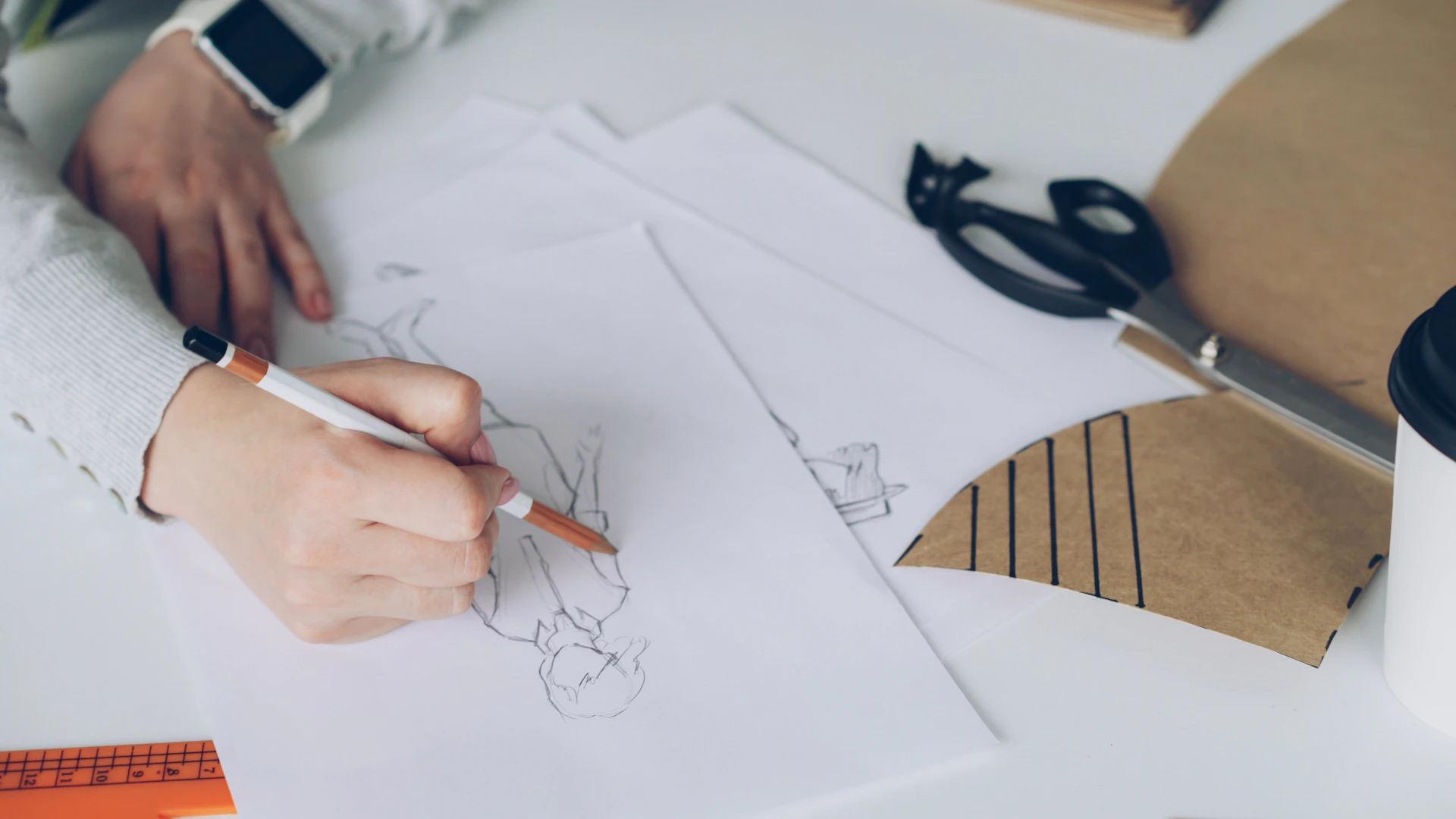 A person sketches a design on paper.