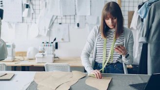 A seamstress uses her phone in her workshop.