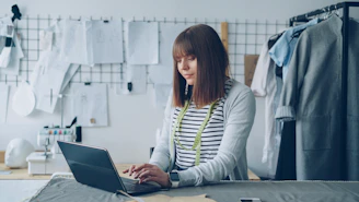 A fashion designer is working on her laptop.