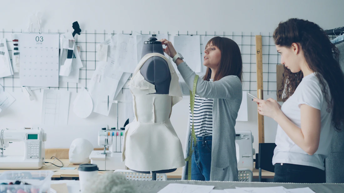 Designers fitting a garment on a dress form