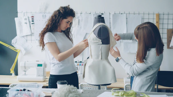 Fashion designers work on a dress form together