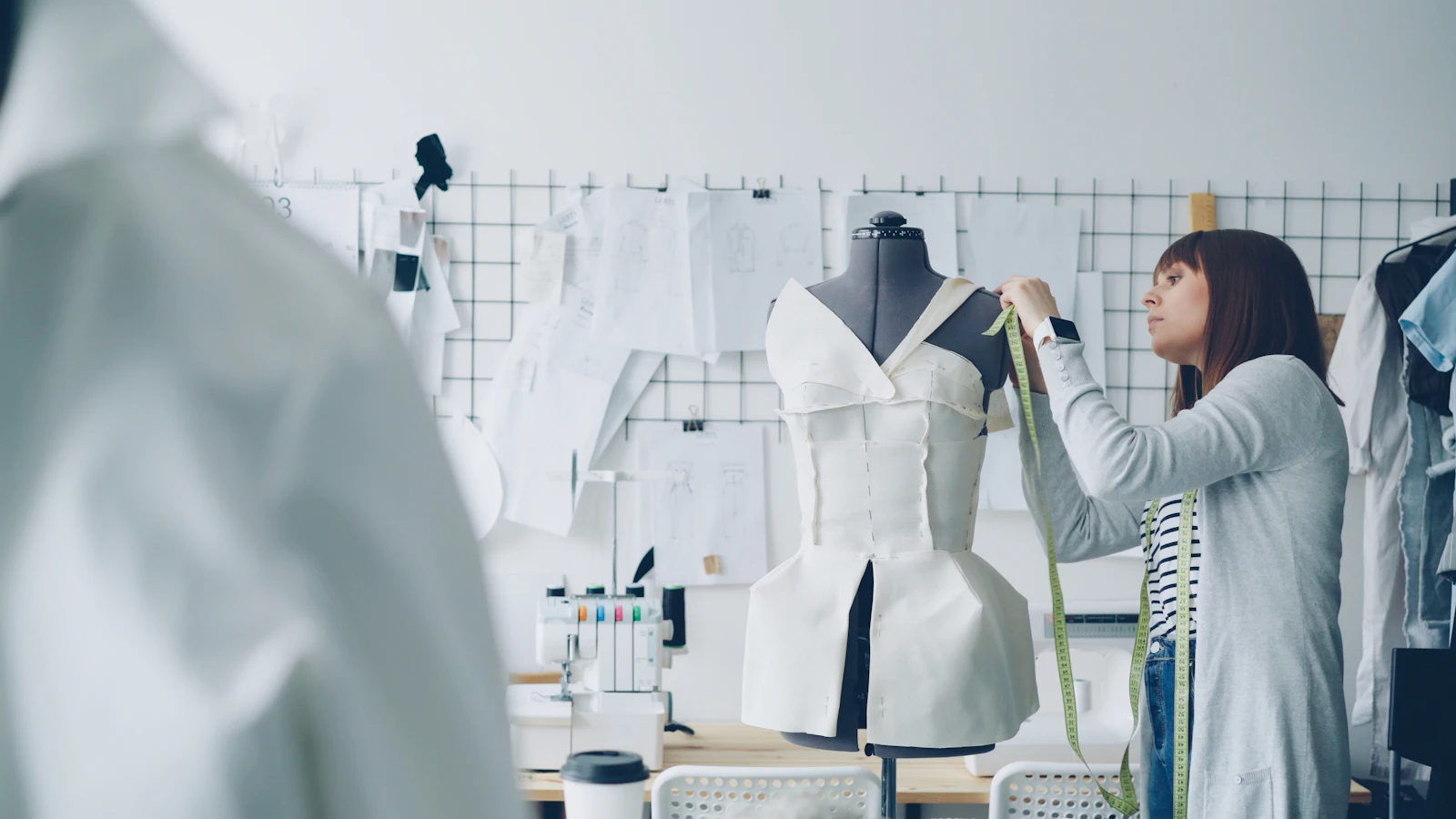 Tailor measuring a garment on a mannequin