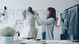 A fashion designer works on a dress form.