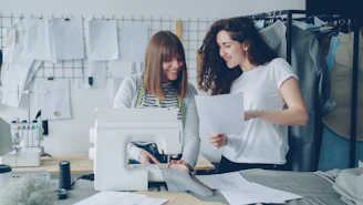 Two women are designing and sewing together