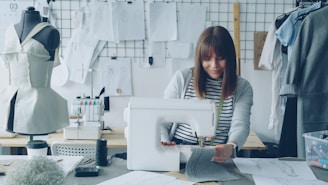 A seamstress is sewing at her work station.