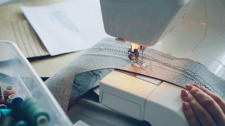 A sewing machine is in use, creating a seam.