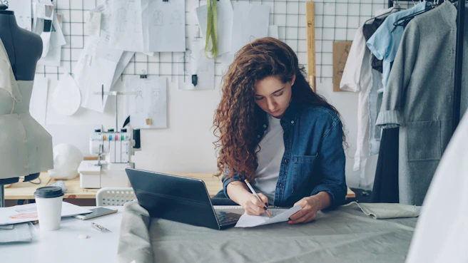 A fashion designer works at her desk