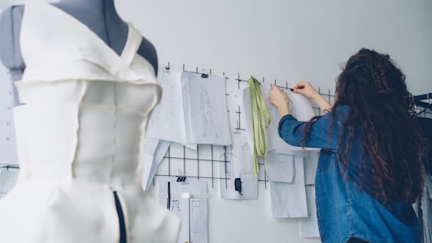 A seamstress works on a garment and its design.
