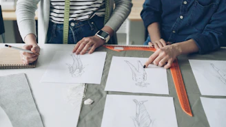 Designers collaborate on fashion sketches and plans.