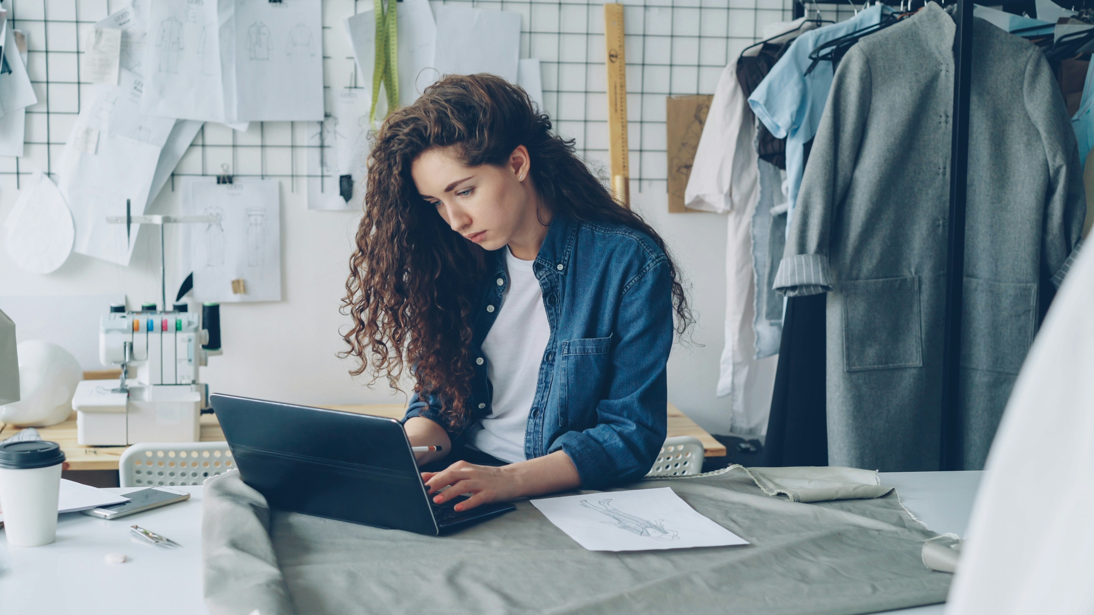 Fashion designer working on a laptop in her studio.
