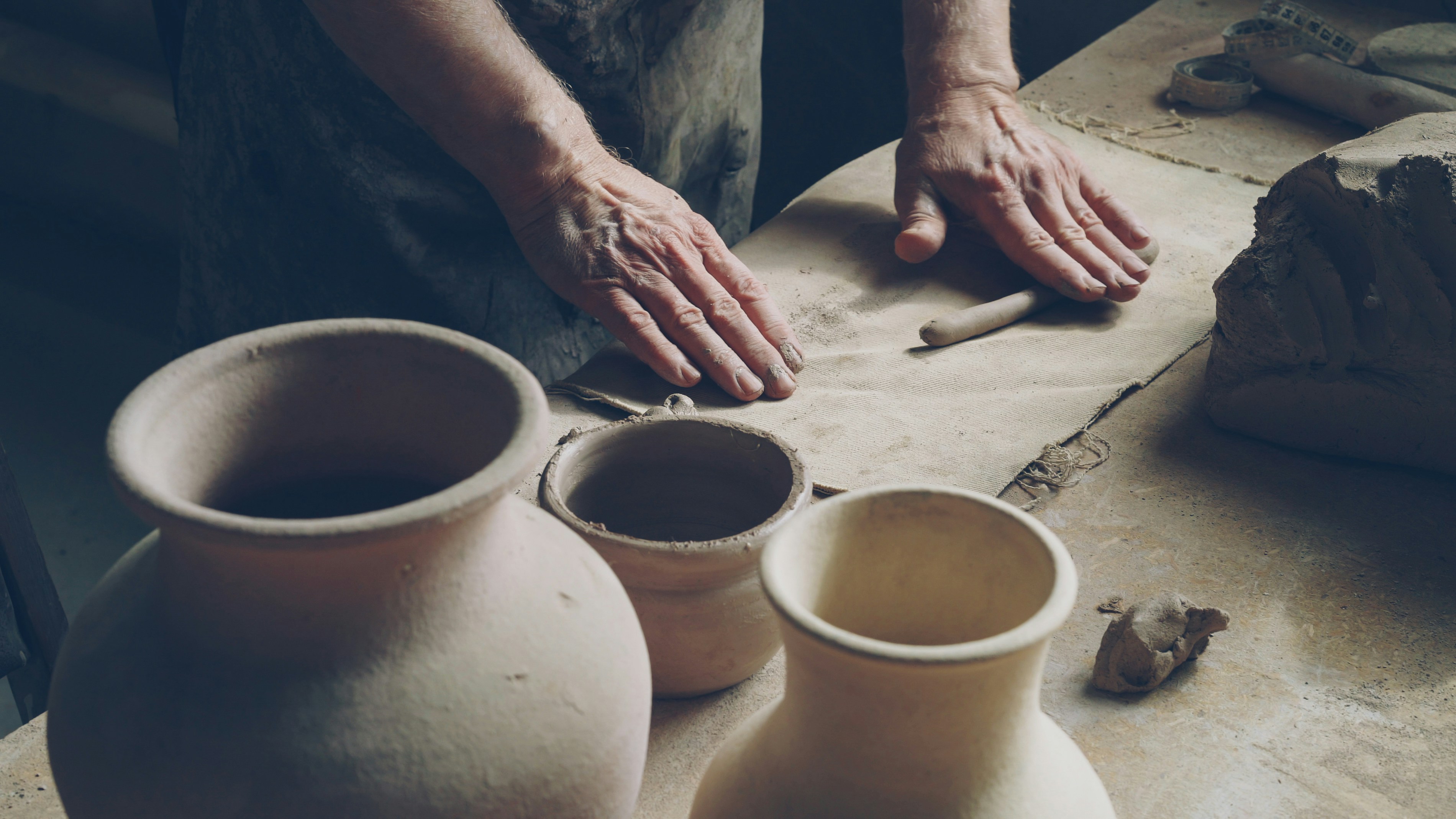 A potter works on his clay pieces.