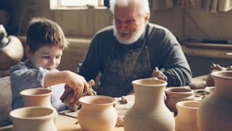 A grandfather teaches his grandson pottery.