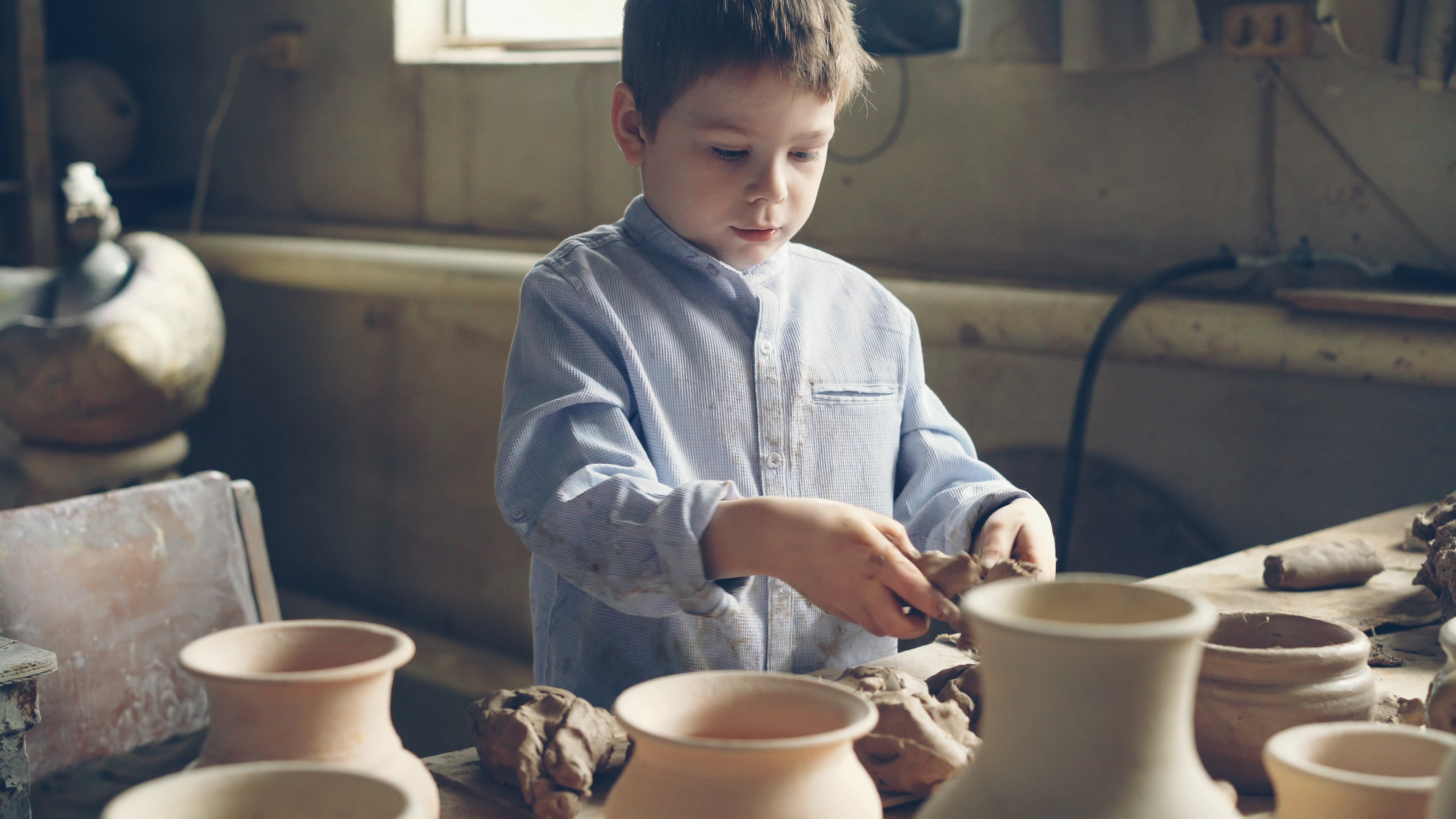 Young elementary children in pottery and watercolor art class