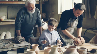 A grandfather, father, and son are working together.