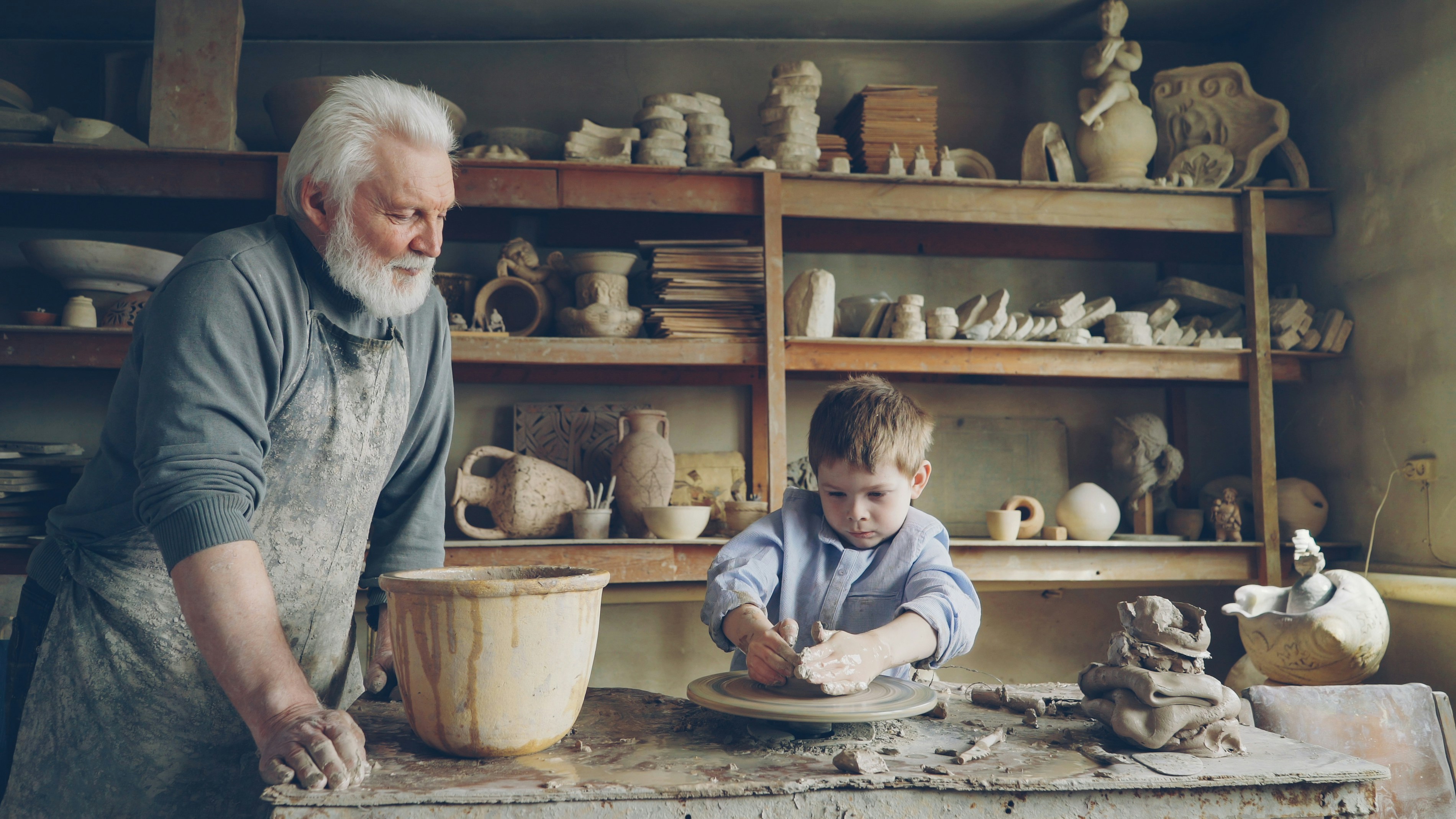 A grandfather watches a child play with clay.