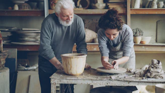 An older man and woman are working on pottery