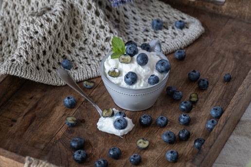 Fresh blueberries and cream in a rustic bowl.
