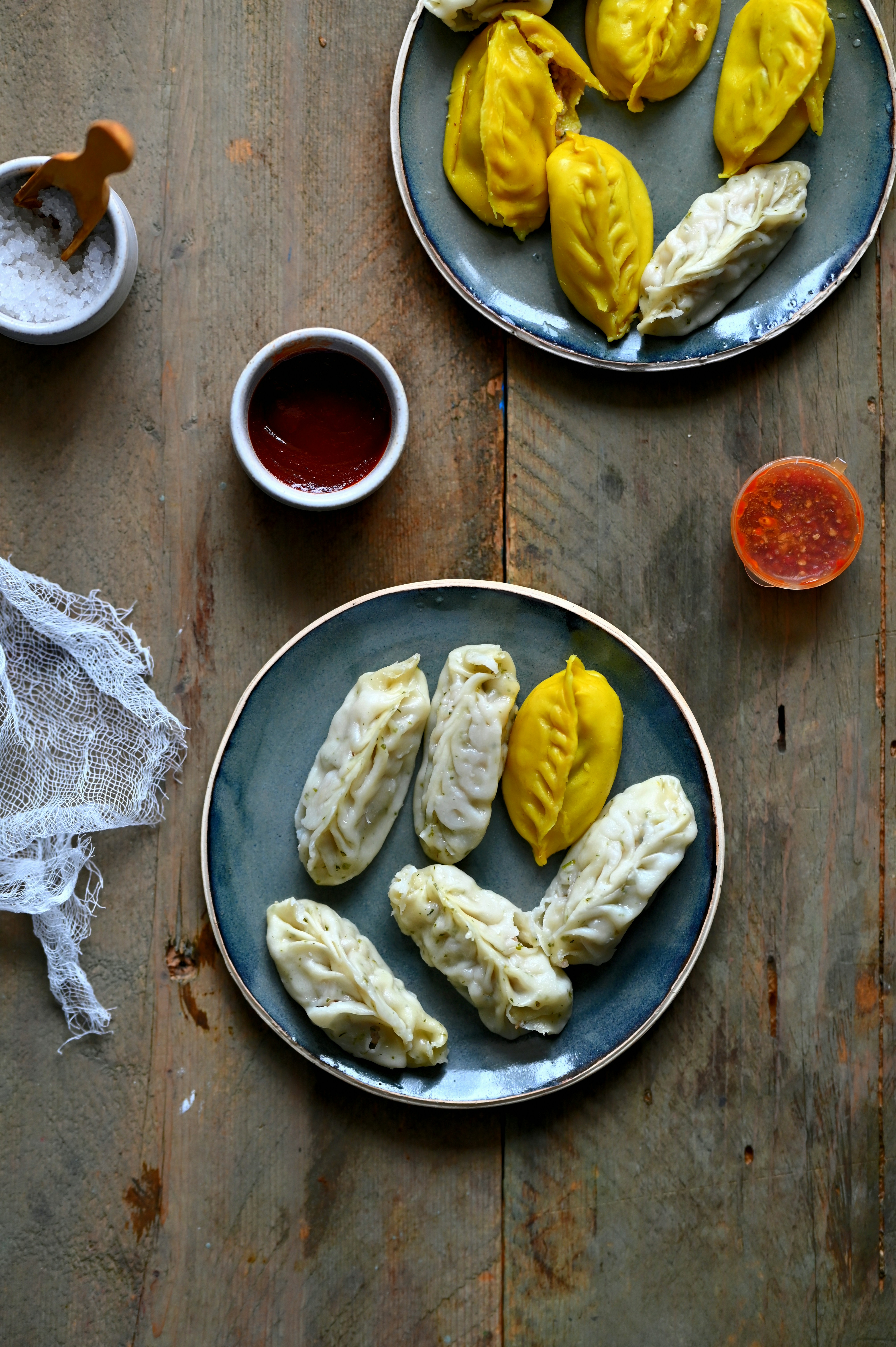 Plates of dumplings with sauces and seasonings.