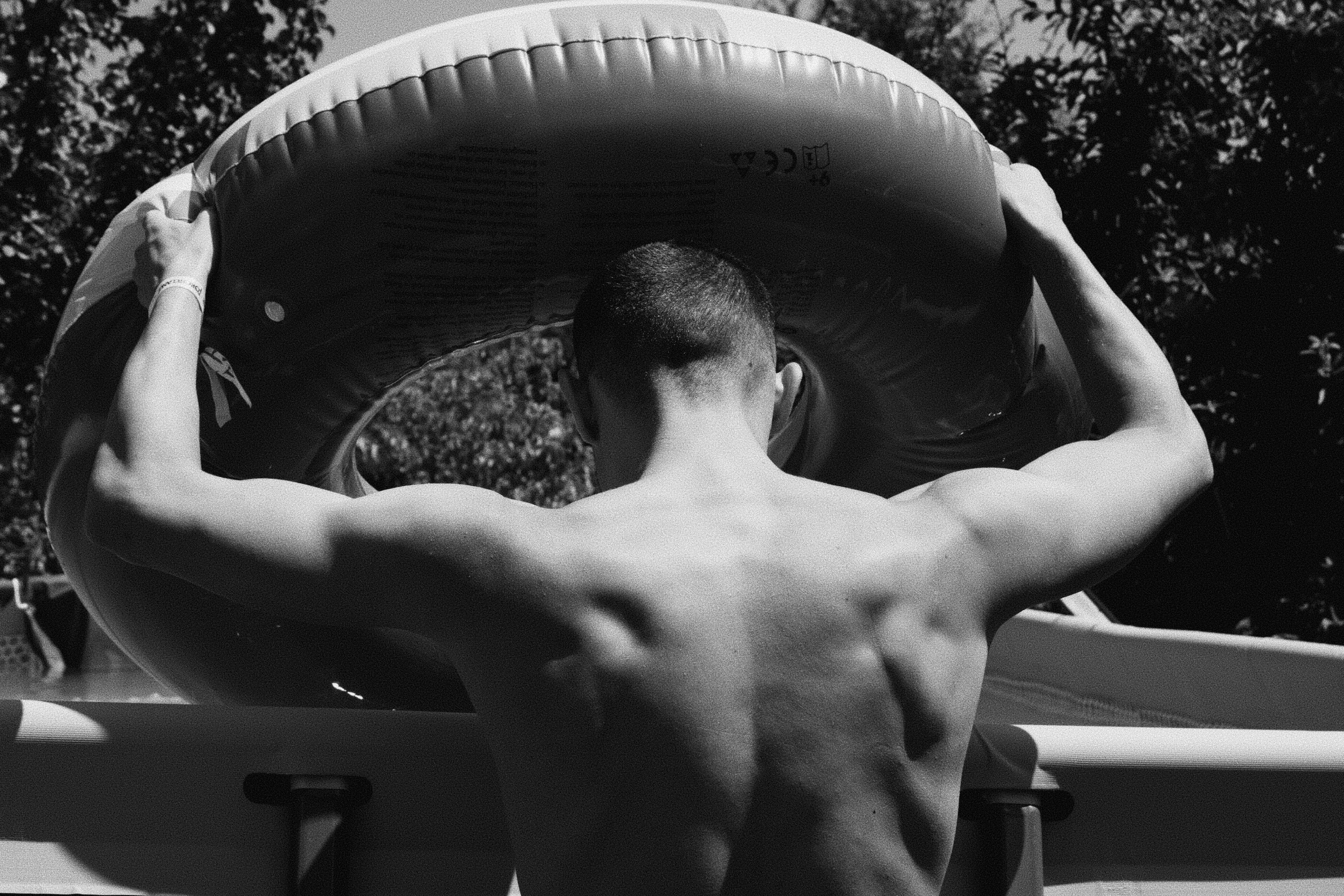 A man carries an inner tube.