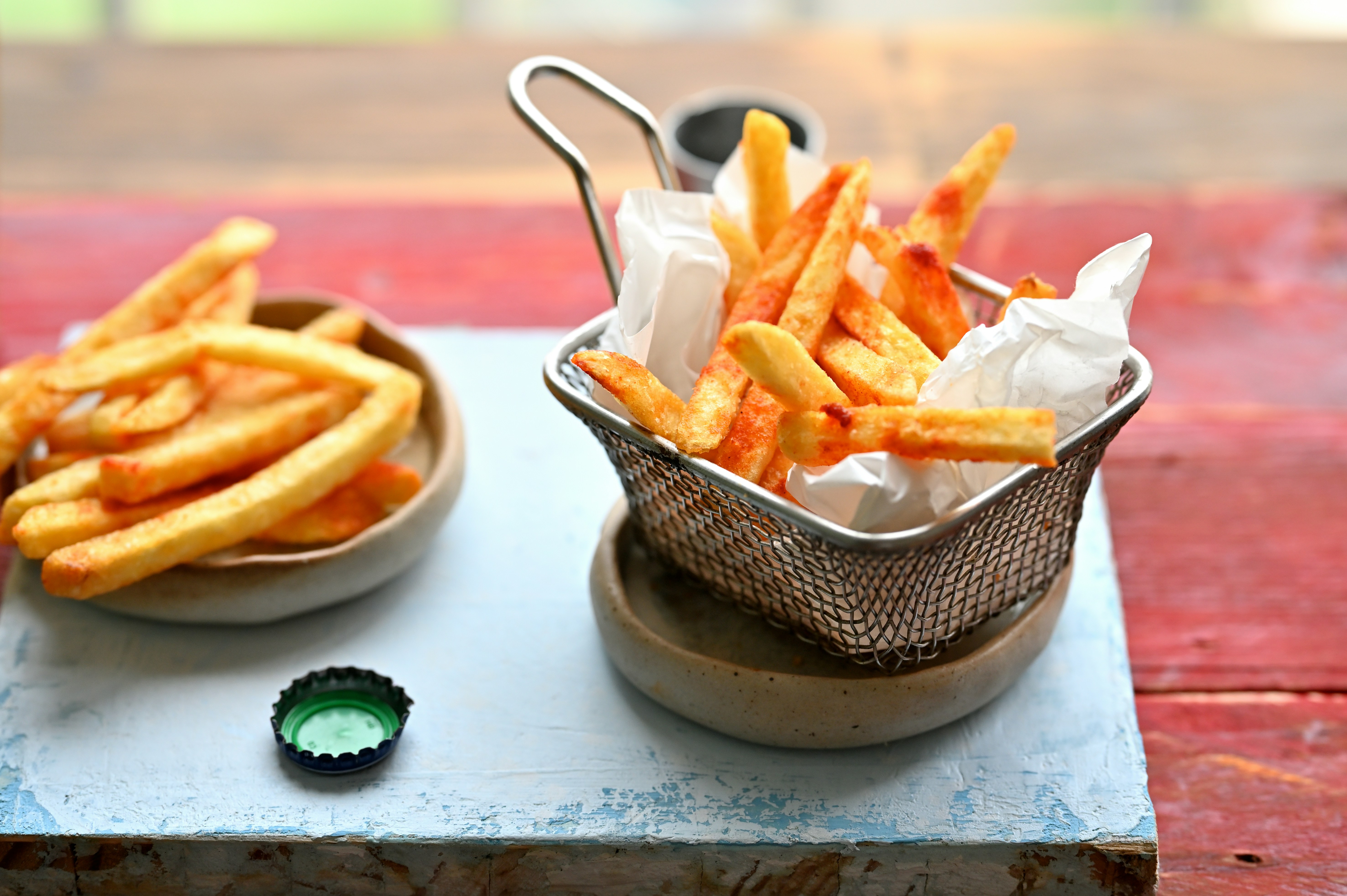 Freshly cooked fries are presented in two containers.