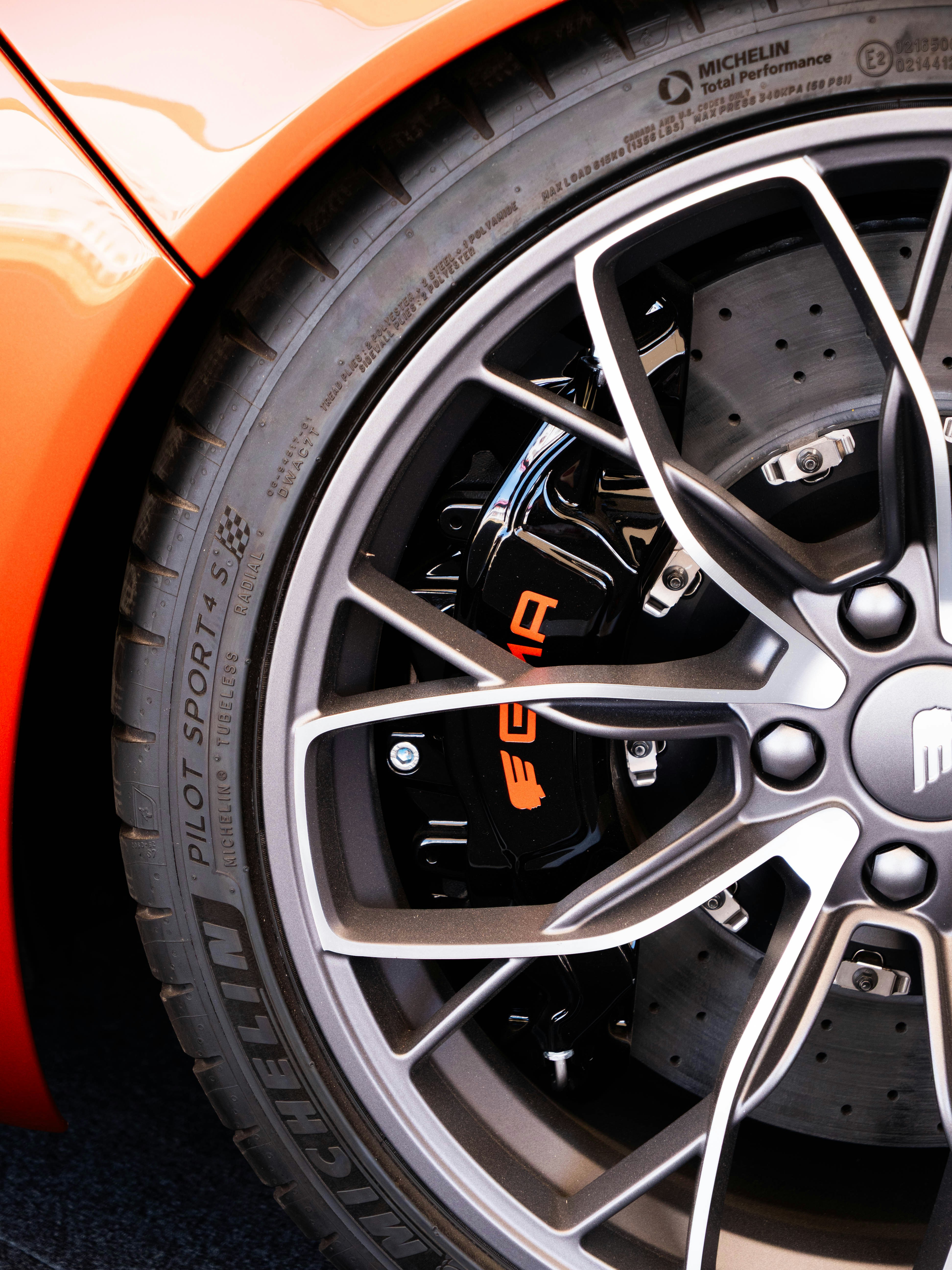 O close-up mostra o aro, o pneu e o sistema de freio de um carro.