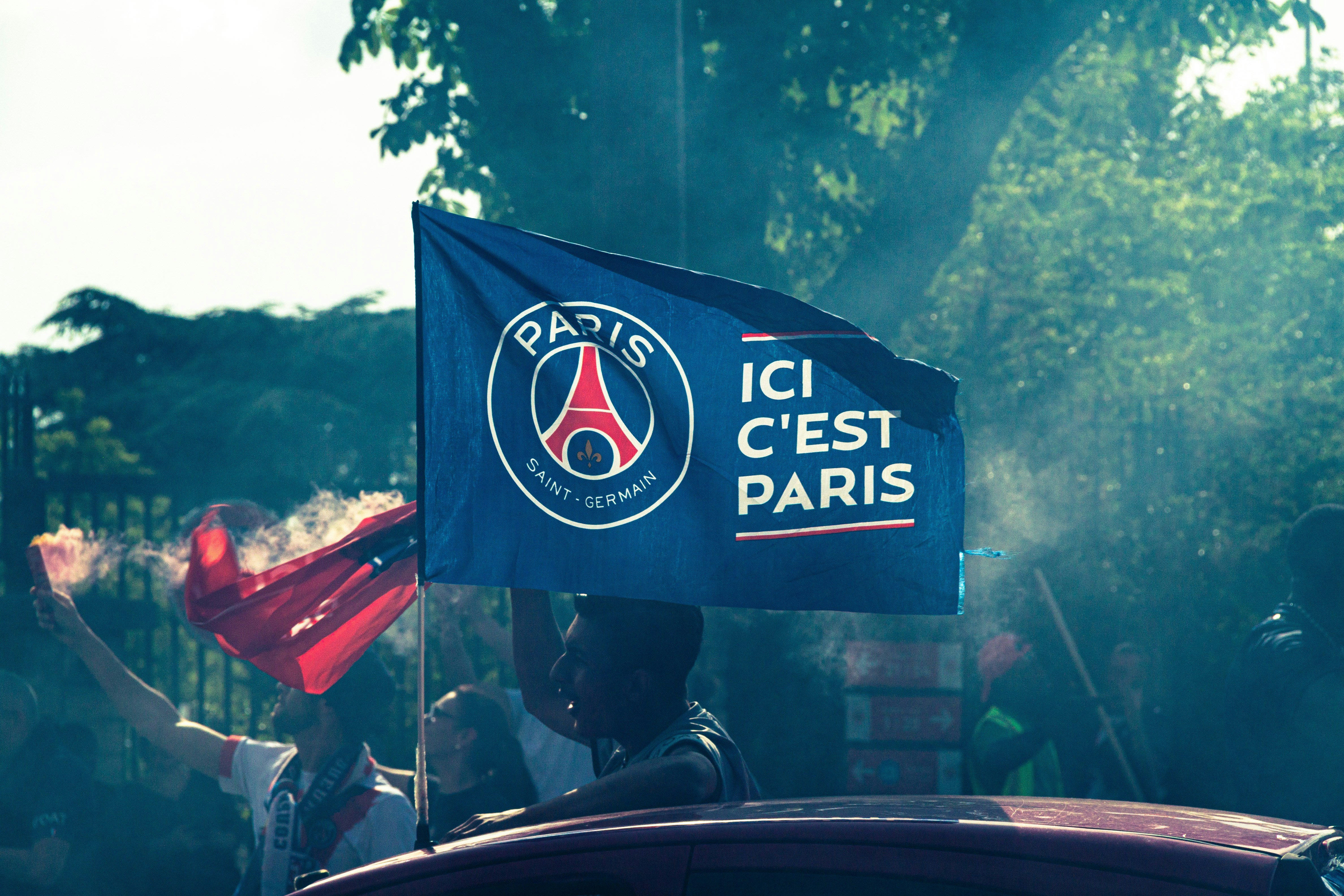 A paris saint-germain flag is waving triumphantly.