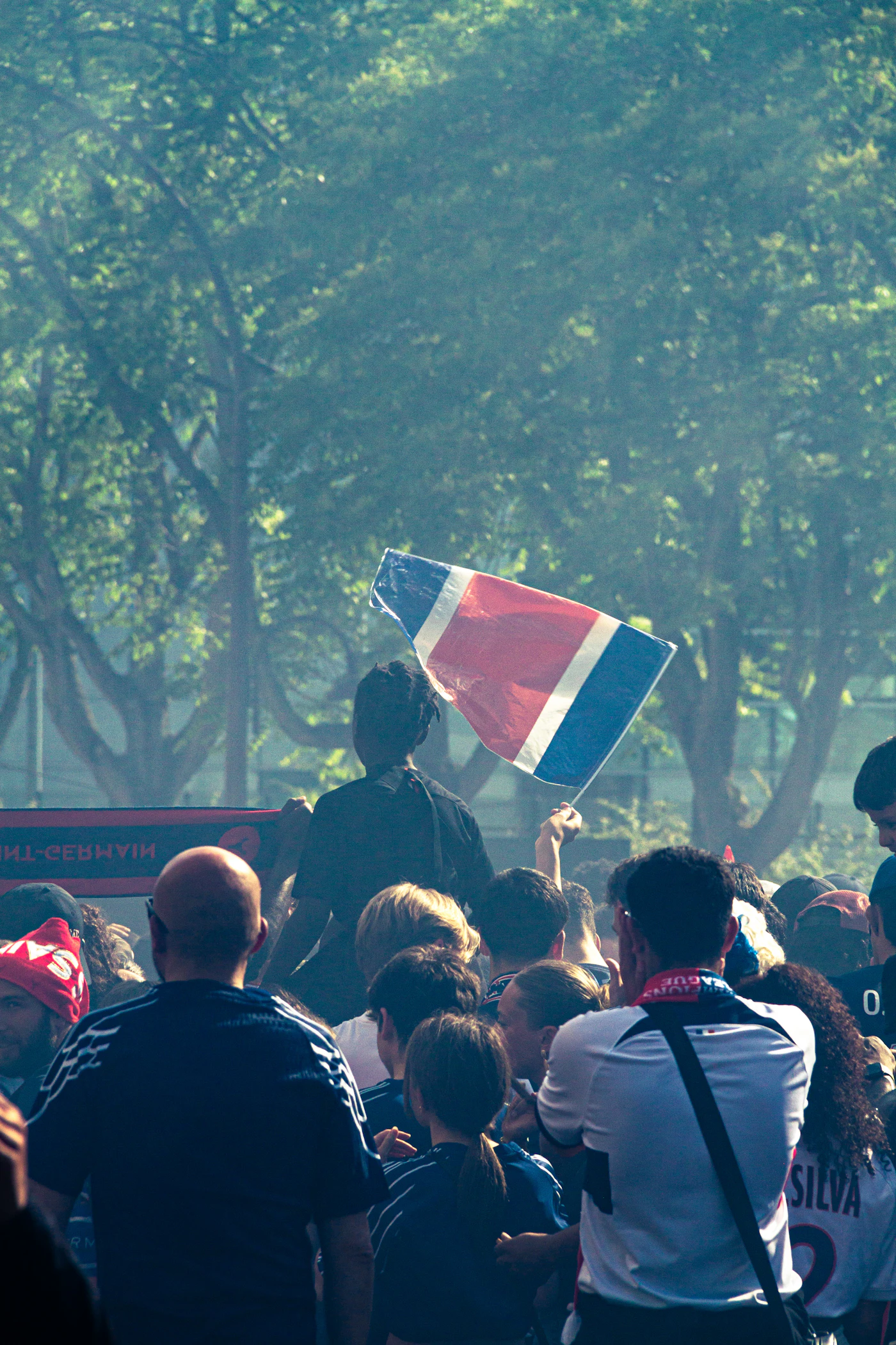 Hinchas celebrando con una bandera en un ambiente de fiesta futbolera durante un gran torneo internacional