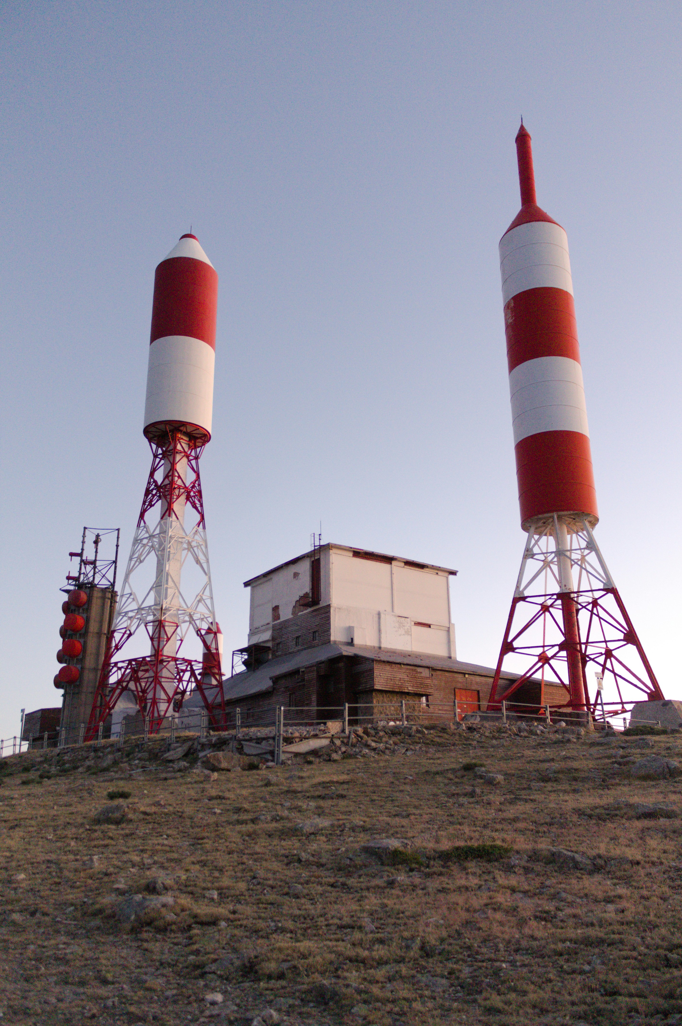 Torres de antenas y un pequeño edificio en una colina.
