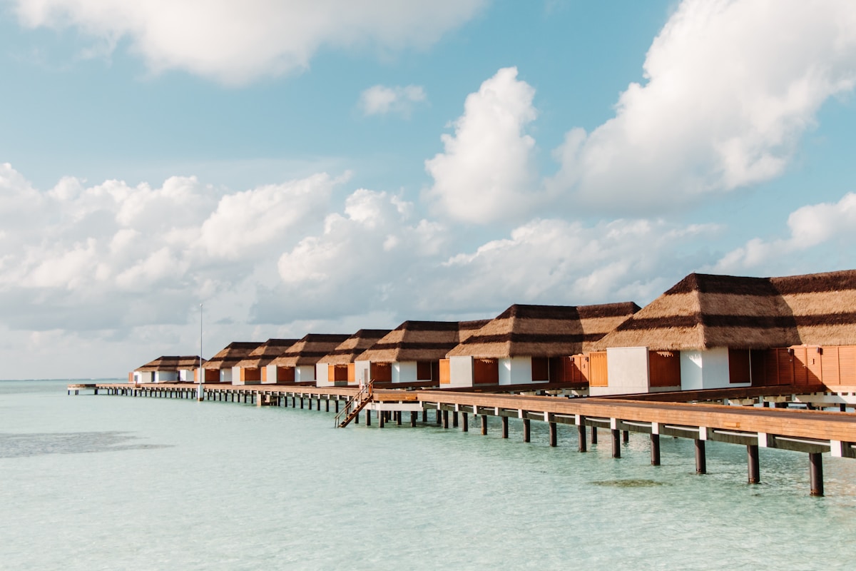 Row of overwater bungalows over a crystal-clear turquoise lagoon