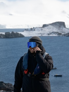 Man in cold weather gear talks on his phone.
