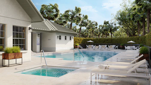 A pool area with loungers and palm trees.