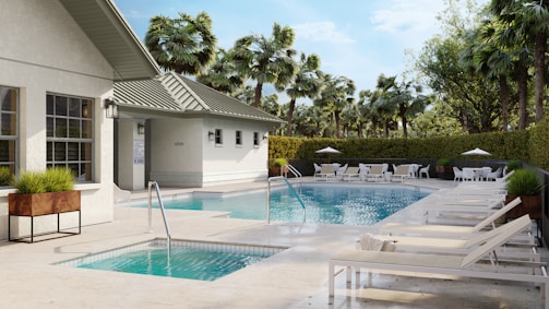 A pool area with loungers and palm trees.