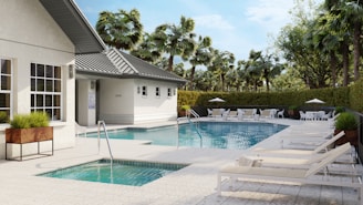 A luxurious pool area with sun loungers and building.