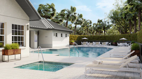 A luxurious community pool area with sun loungers and building.