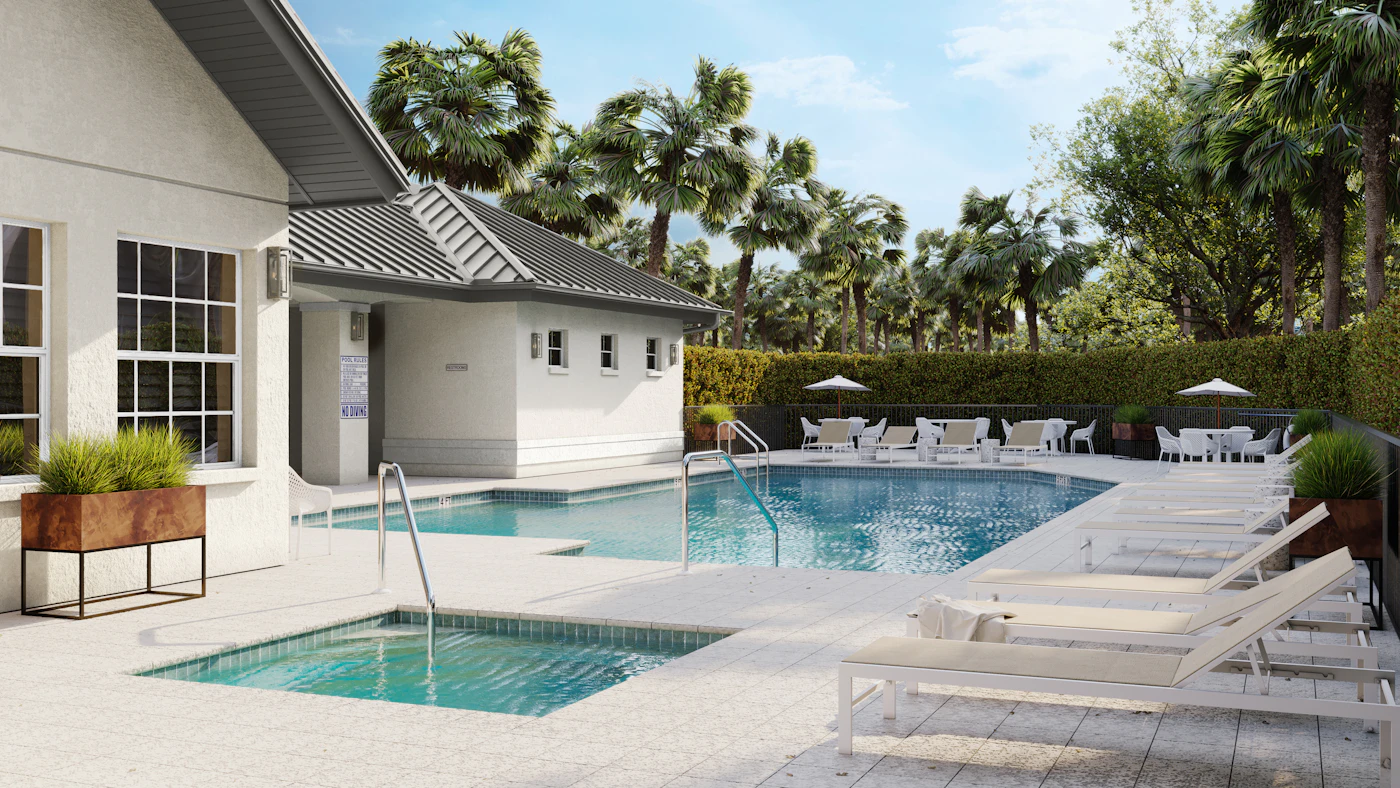 A pool and spa with stone coping, a white pool house and palms