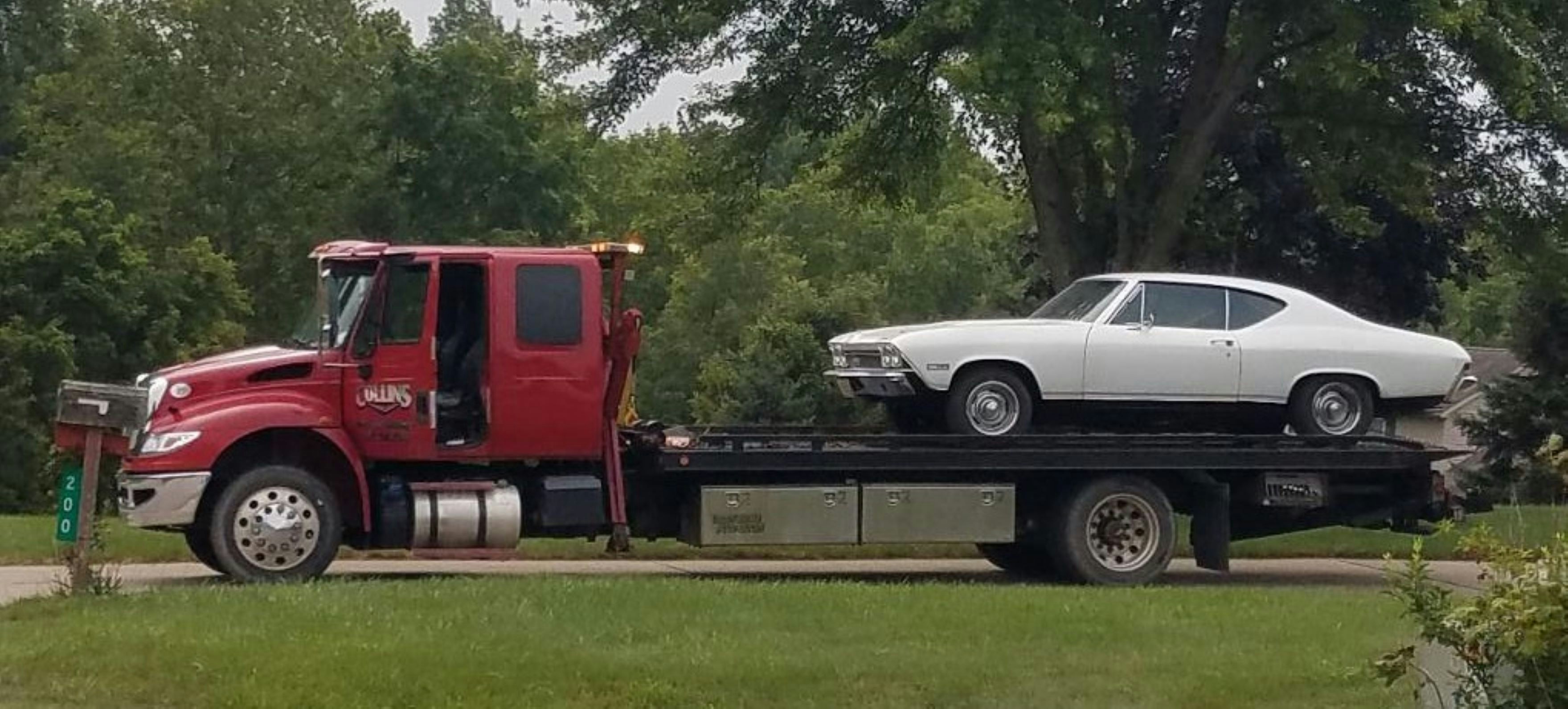 A classic white car is being towed.