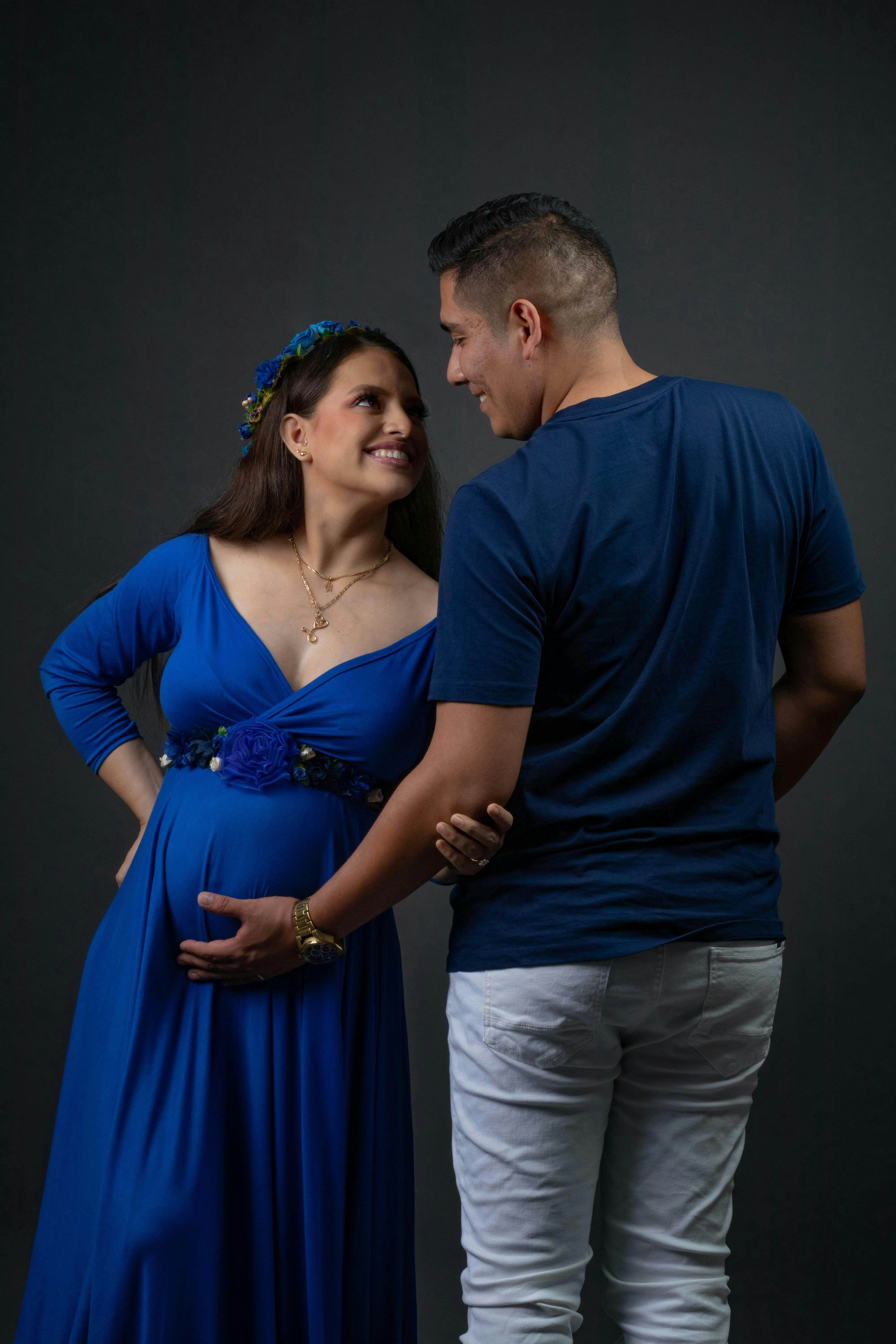 Happy parents-to-be lovingly look at each other.