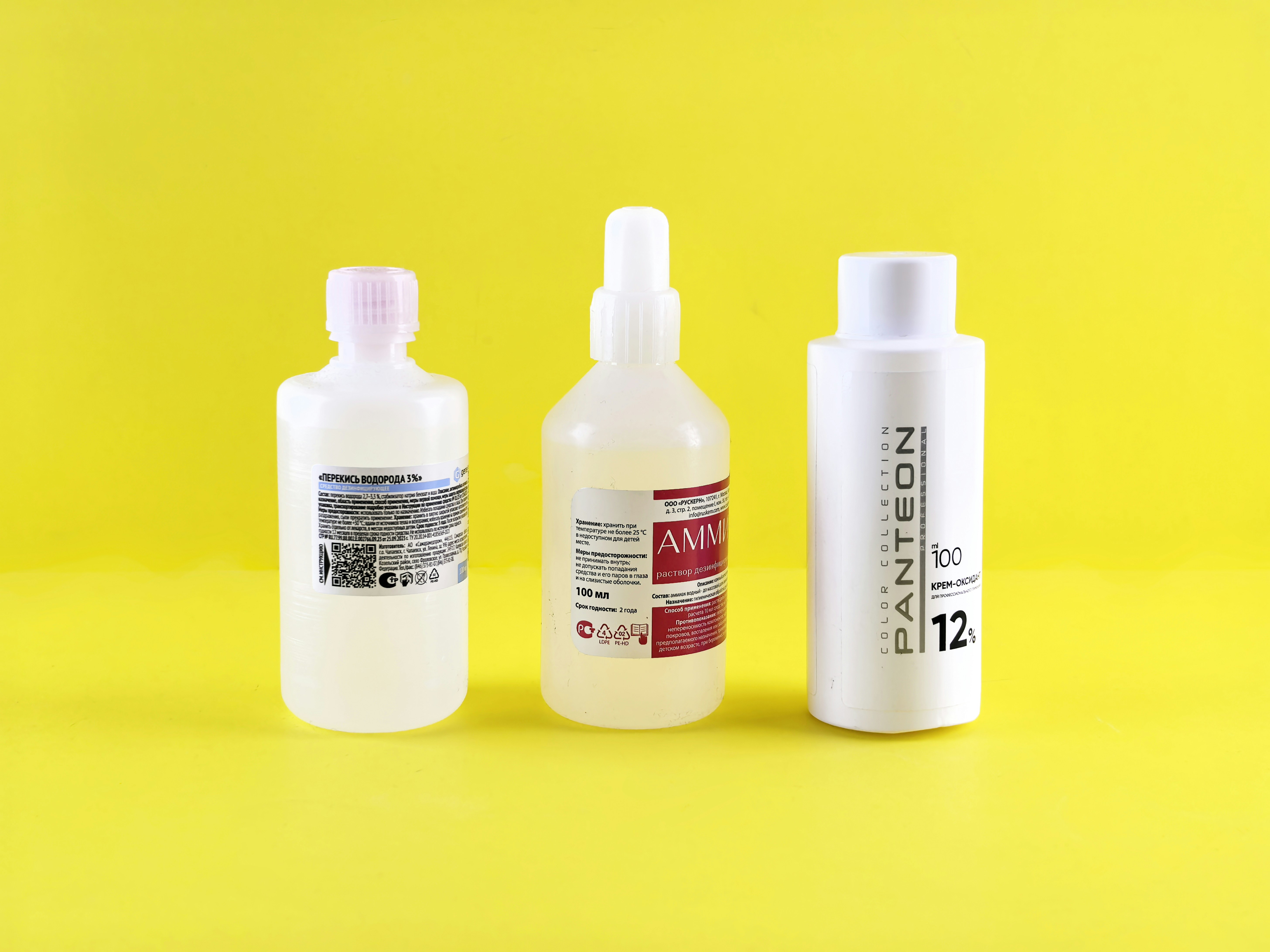 Three bottles are lined up on a yellow background.