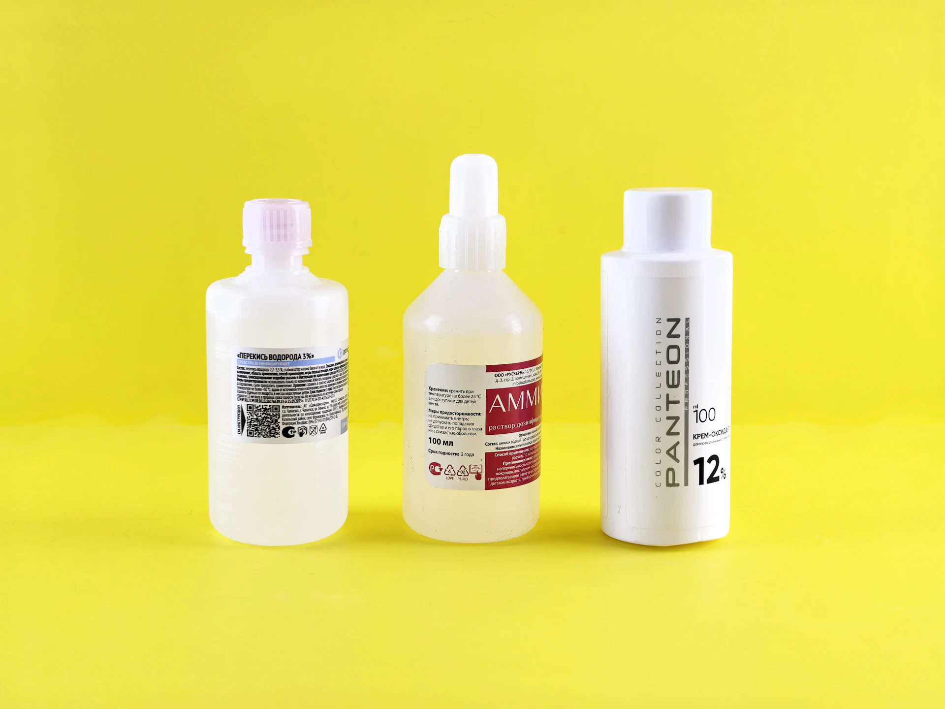 Three bottles are lined up on a yellow background