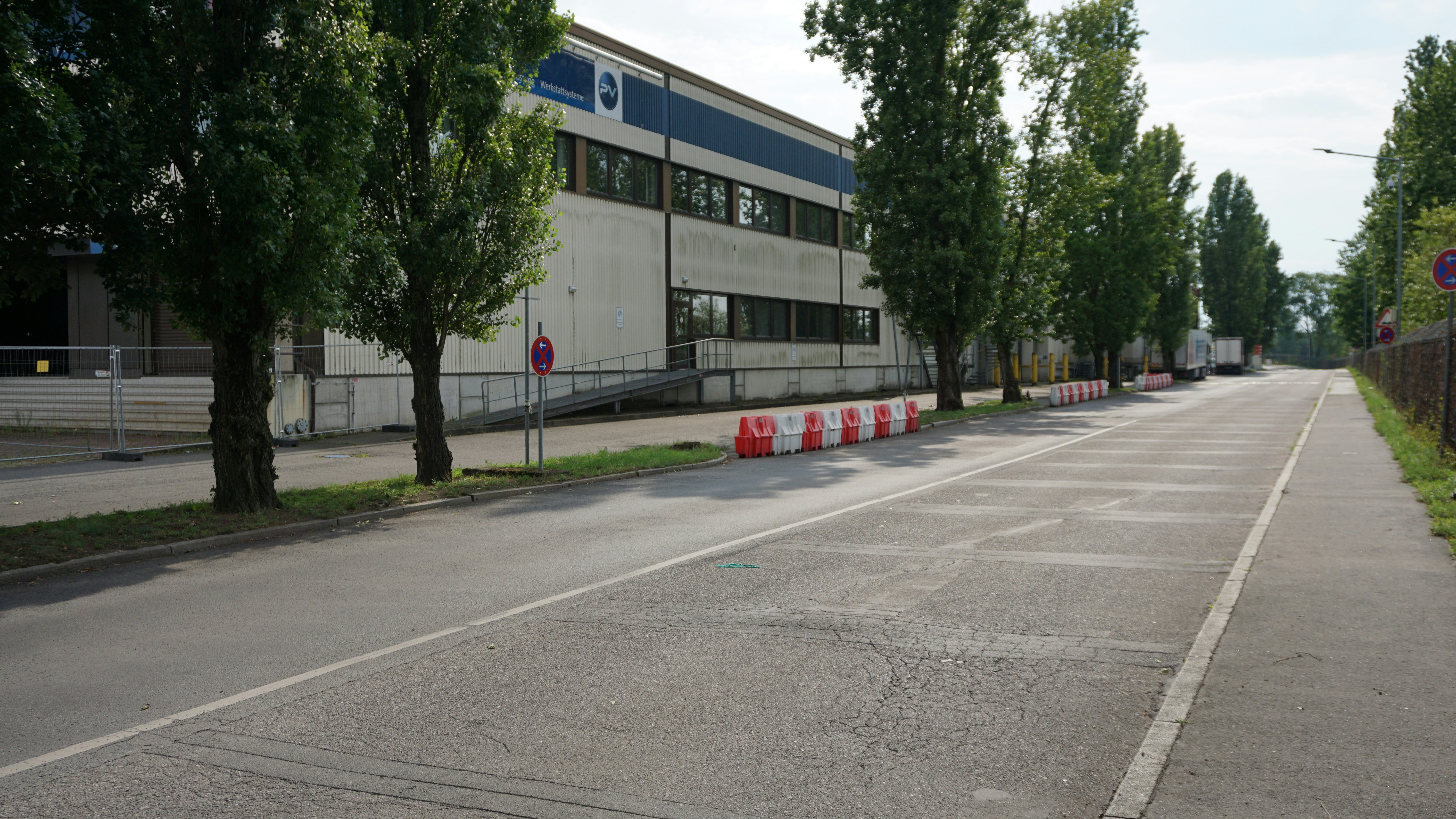 A road leads past a large industrial building.