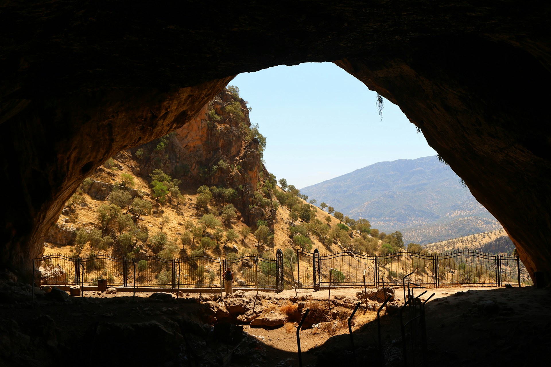 View from within a cave showcasing mountains.