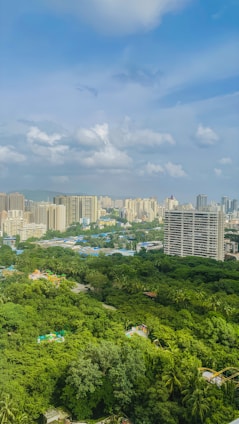 Cityscape with buildings and lush green trees.